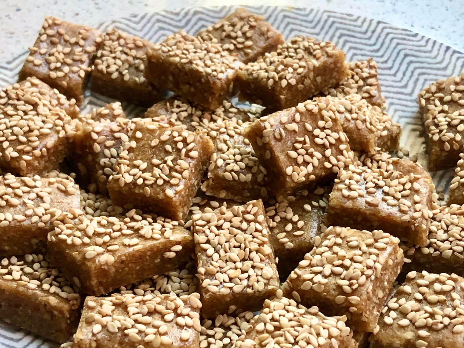 A plate of sesame sprinkled date squares - an anti-inflammatory diet recipe.