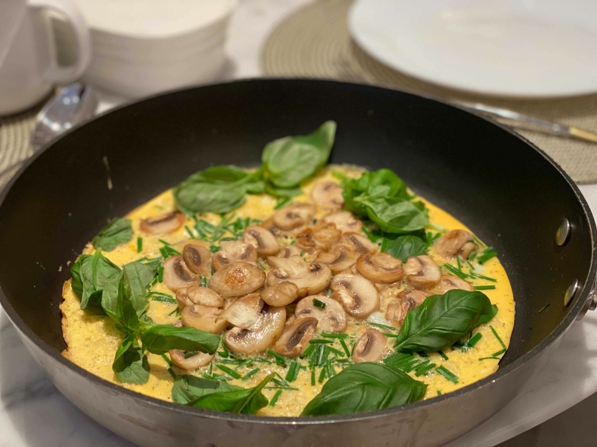 A pan of omelette made with mushrooms and basil with other herbs - a recipe for good digestive health.