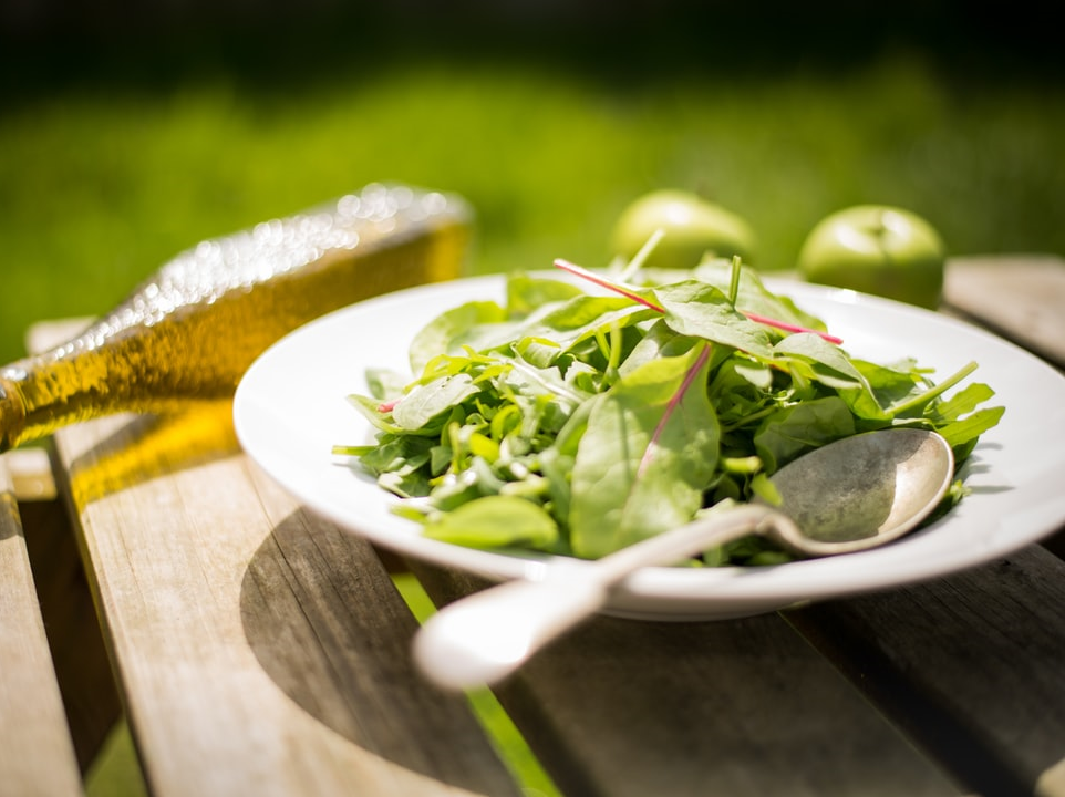 A dish with salad leaves to showcase an apple cider vinaigrette.