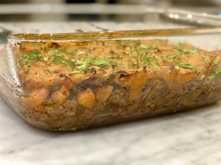 A clear casserole dish containing sweet potato cottage pie, which is a recipe for a healthy gut.