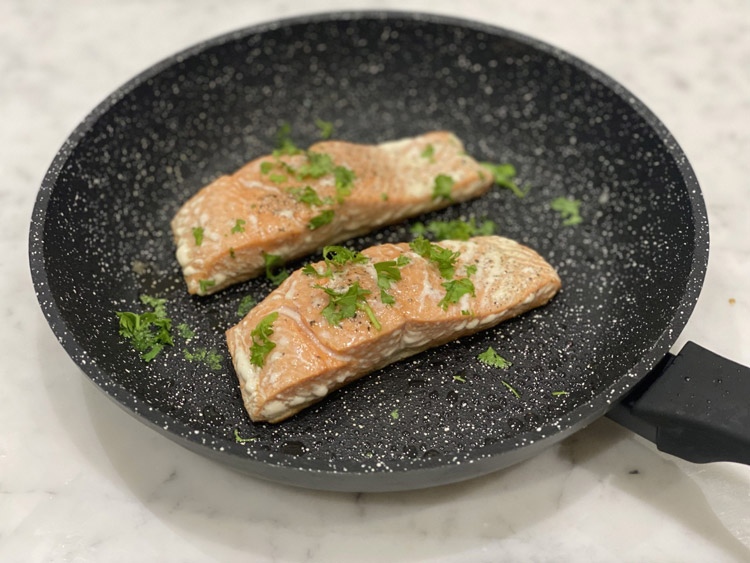 A pan with freshly seared salmon, which is a quick recipe from a low inflammatory lifestyle plan.