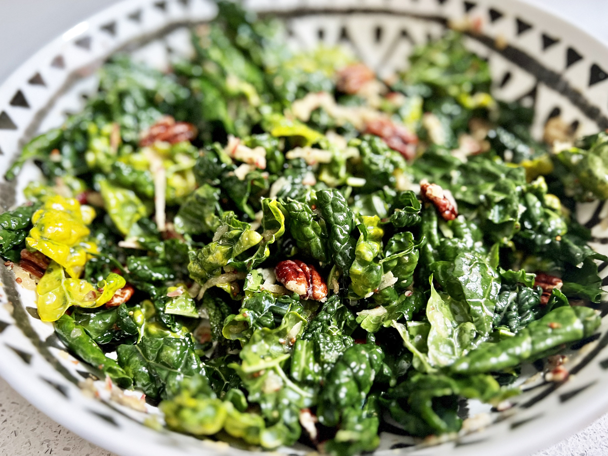 A bowl of kale, chopped apple, and pecans salad