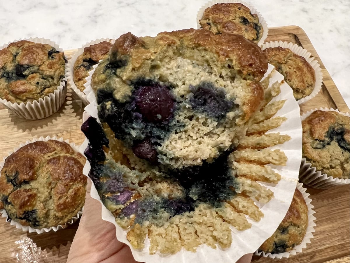 Lemon and Blueberry Protein Muffins in a cupcase case missing a bite