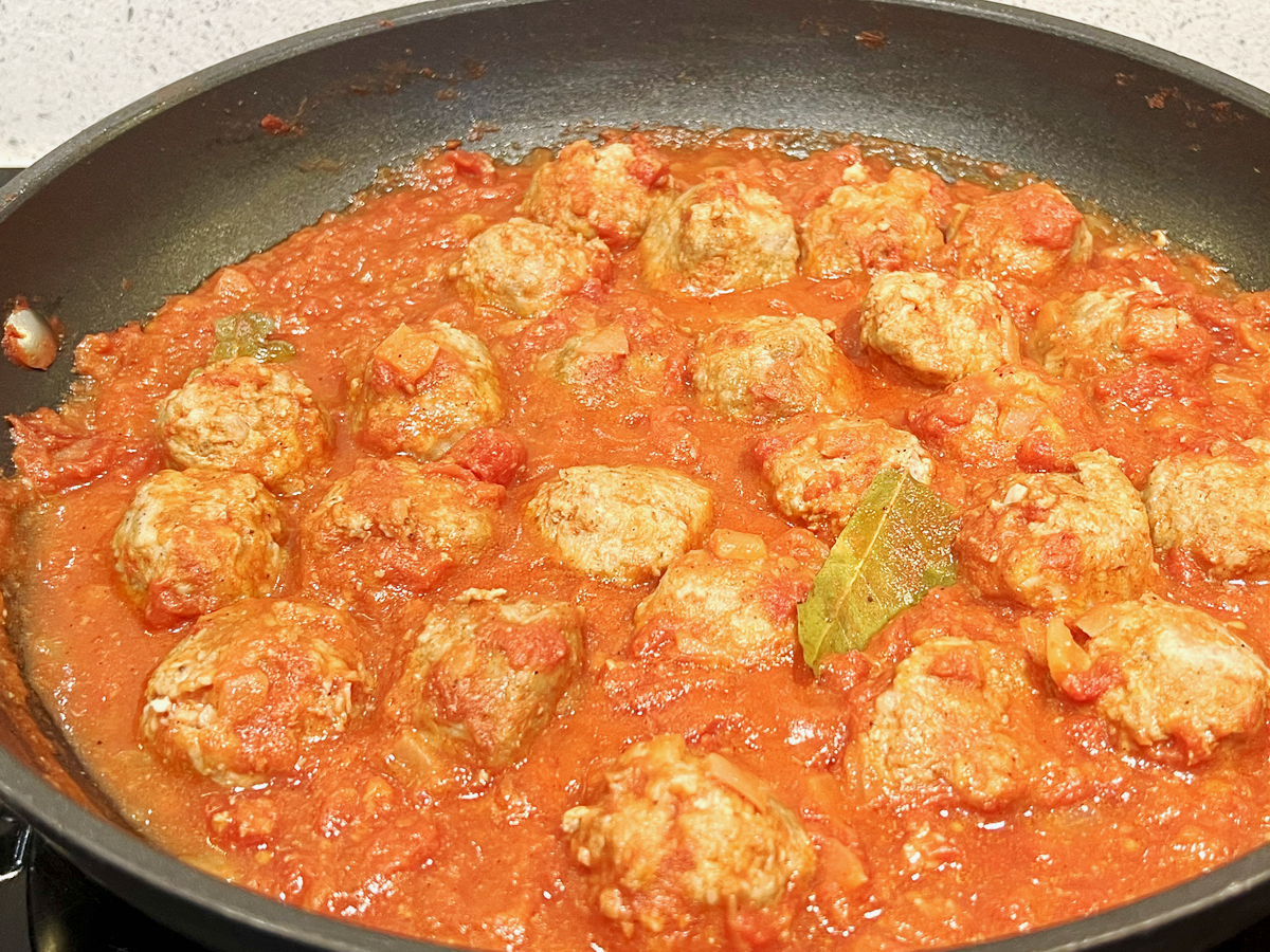 meatballs in tomato sauce and a bay leaf on top