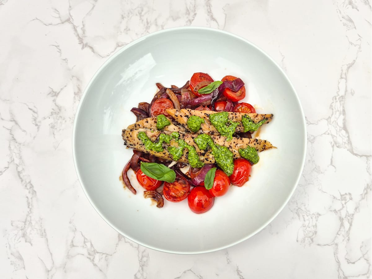 A bed of caramalized red onion served with tomatoes and mackerel