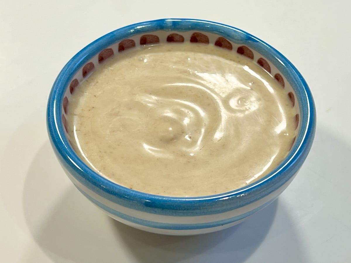 a ramekin with a dairy-free curry and yogurt dressing