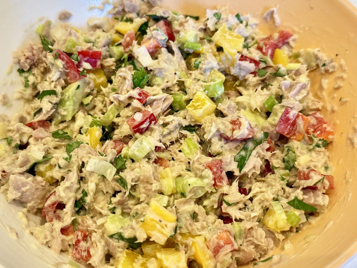 a bowl of a colorful tuna salad with bell peppers and scallions in an avoicado oil mayonnaise