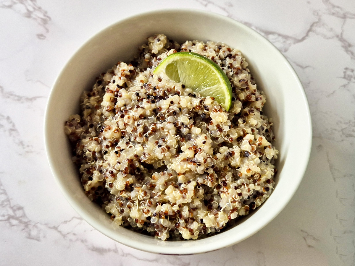 a bowl of miso quinoa served with a wedge of lime